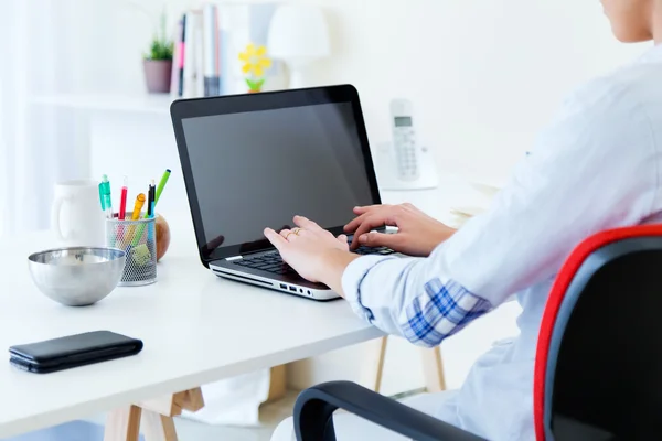 Mooie jonge vrouw met behulp van haar laptop in het kantoor. — Stockfoto