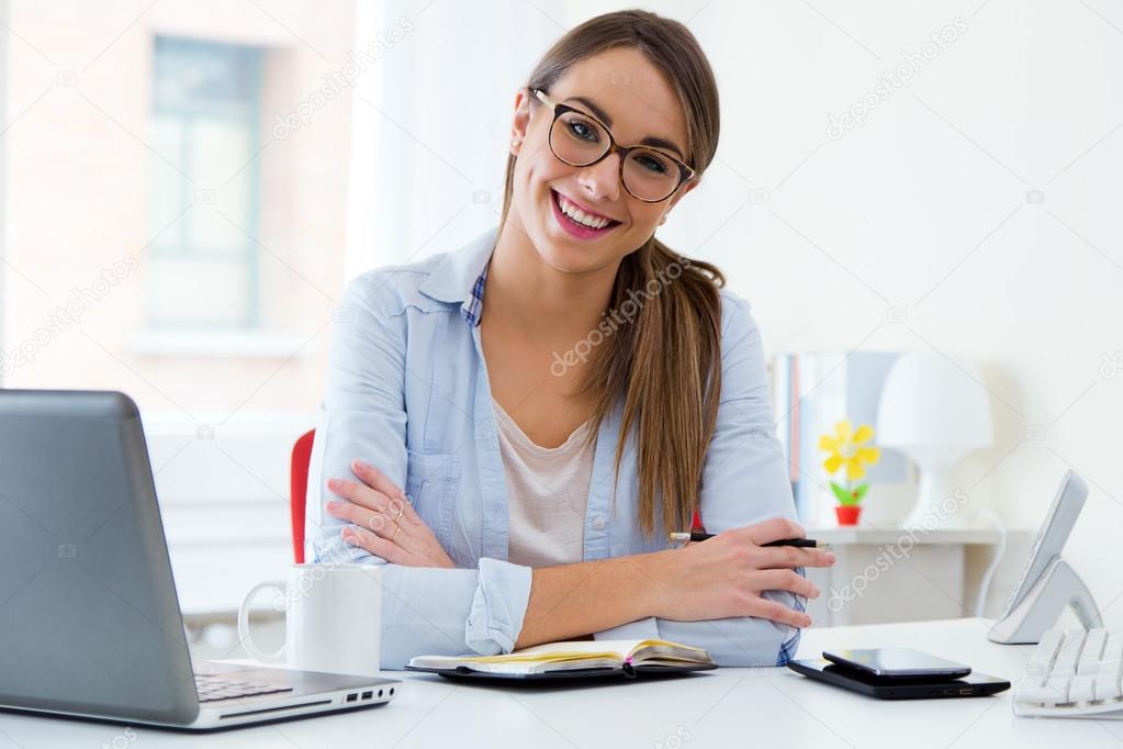 Pretty young woman working in her office.