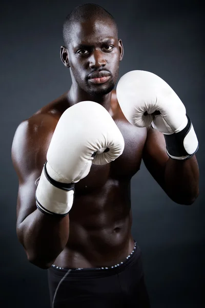 Joven boxeador atlético con guantes en fondo negro . —  Fotos de Stock