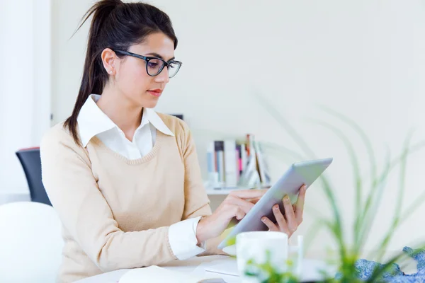 Jeunes femmes d'affaires travaillant avec une tablette numérique dans son bureau . — Photo