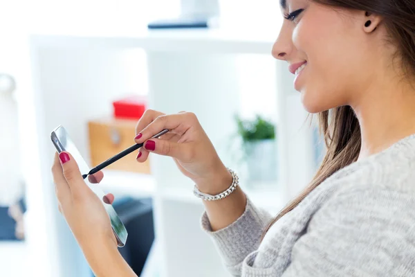 Beautiful young woman using her mobile phone at home. — Stock Photo, Image