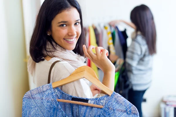 Twee mooie meisjes winkelen in een winkel kleding. — Stockfoto