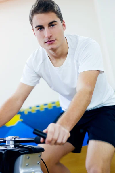 Jóvenes con bicicleta de fitness en el gimnasio . — Foto de Stock