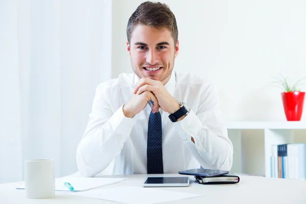 Jonge knappe man aan het werk in zijn kantoor. — Stockfoto