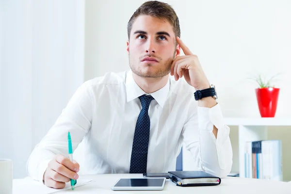 Junger schöner Mann arbeitet in seinem Büro. — Stockfoto