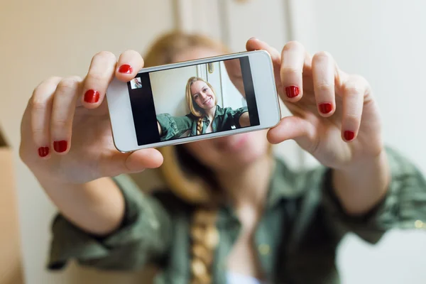 Jovem bela mulher tirando uma selfie com smartphone em seu novo — Fotografia de Stock