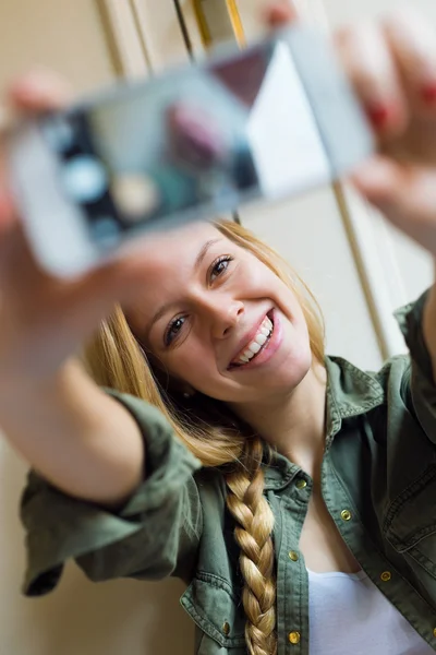 Jovem bela mulher tirando uma selfie com smartphone em seu novo — Fotografia de Stock