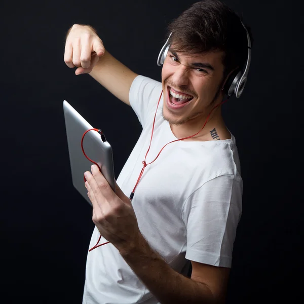 Jonge mooie man luisteren naar muziek. Geïsoleerd op zwart. — Stockfoto