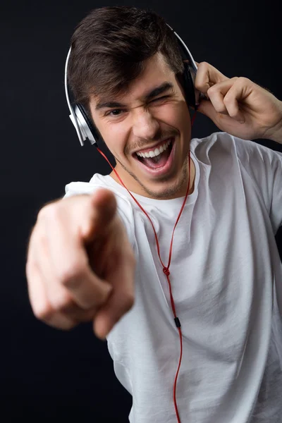 Jonge mooie man luisteren naar muziek. Geïsoleerd op zwart. — Stockfoto