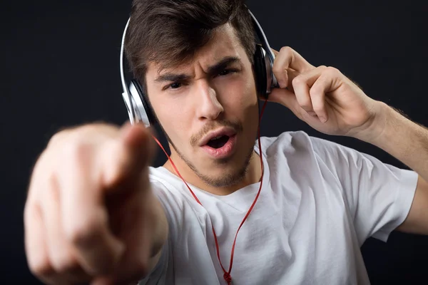 Jonge mooie man luisteren naar muziek. Geïsoleerd op zwart. — Stockfoto