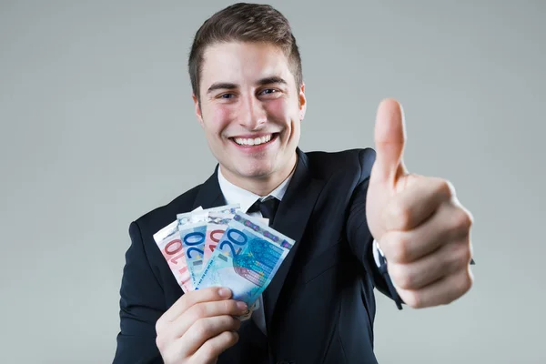 Ung man i formalwear hålla pengar. — Stockfoto