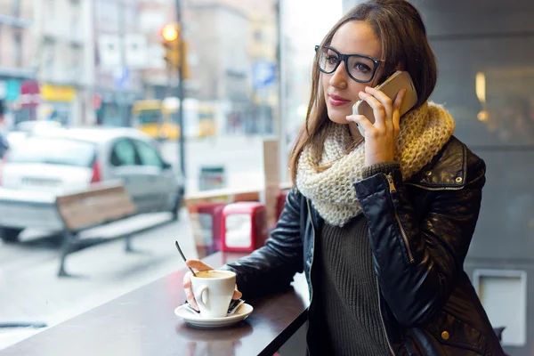 Vacker flicka med sin mobiltelefon i café. — Stockfoto