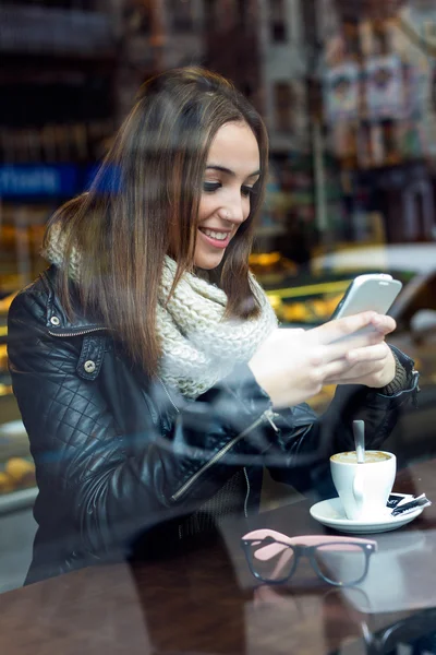 Bella ragazza che utilizza il suo telefono cellulare in caffè . — Foto Stock