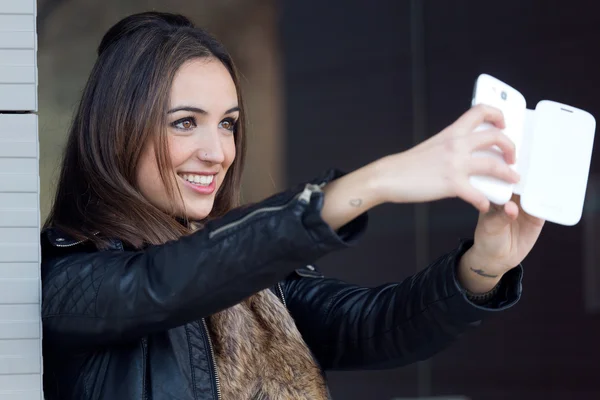 Jeune belle femme prenant un selfie dans la rue . — Photo