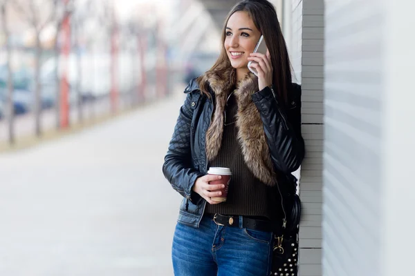 Mujer hermosa joven con teléfono móvil y café . — Foto de Stock