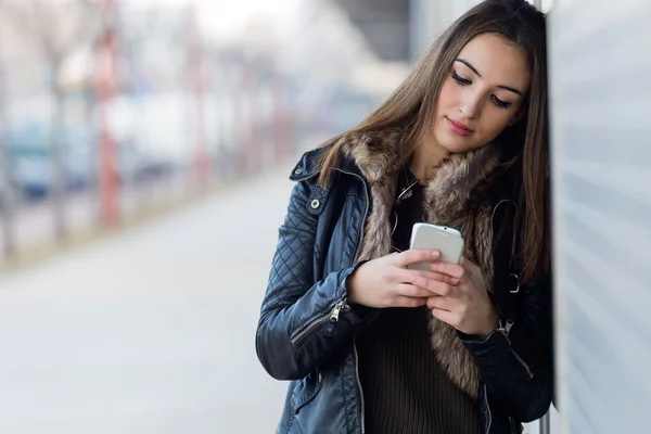 Ung vacker kvinna med mobiltelefon i gatan. — Stockfoto