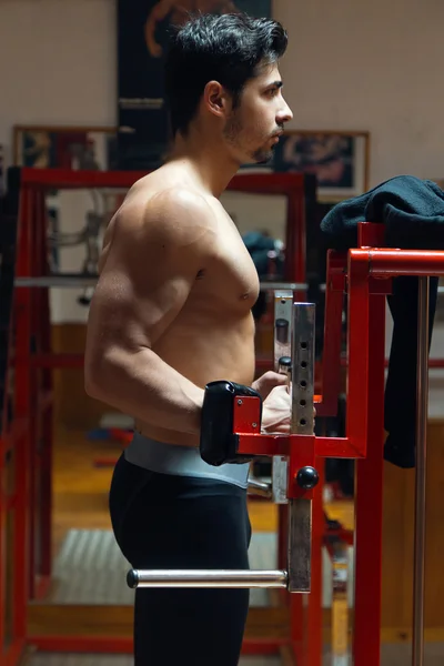 Jeune homme faisant un exercice de poids lourd dans la salle de gym . — Photo