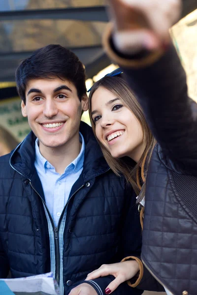 Pareja de turistas jóvenes utilizan su mapa y señalan donde quieren — Foto de Stock