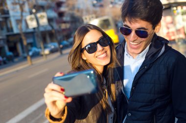Mutlu genç çift selfies smartphone ile alarak.
