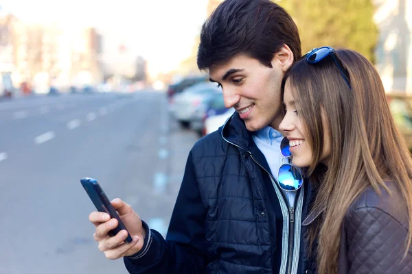 Jovem casal de turistas na cidade usando telefone celular . — Fotografia de Stock