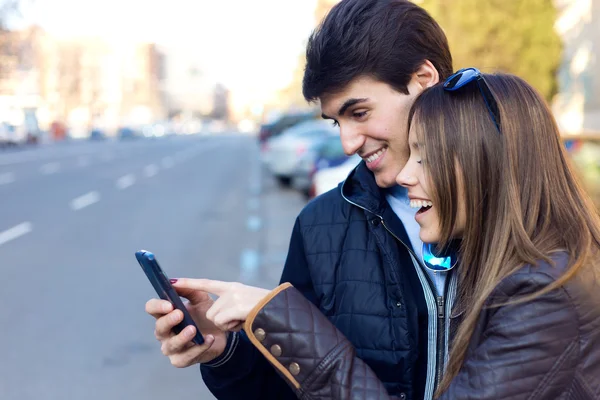 Jovem casal de turistas na cidade usando telefone celular . — Fotografia de Stock