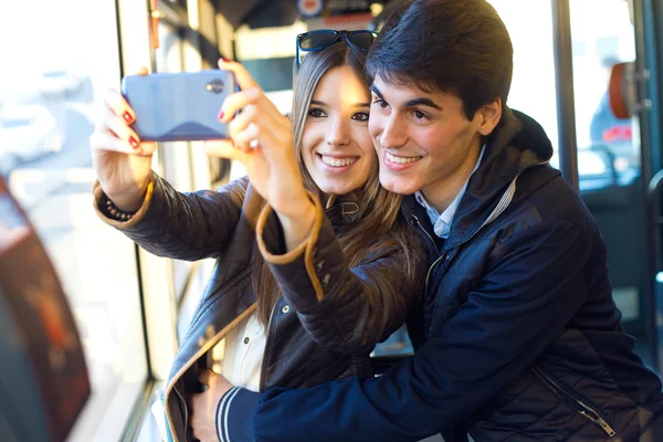 Junges Paar macht Selfies mit Smartphone im Bus. — Stockfoto