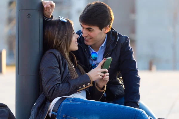 Pareja joven de turista en la ciudad usando teléfono móvil . — Foto de Stock