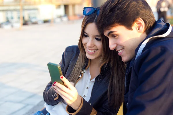 Giovane coppia di turisti in città utilizzando il telefono cellulare . — Foto Stock