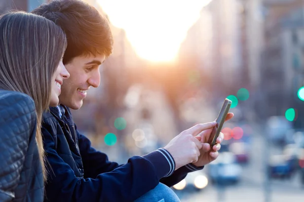 Молодая пара туристов в городе с помощью мобильного телефона . — стоковое фото