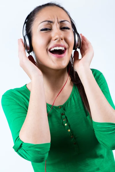 Bella giovane donna che ascolta musica. Isolato su bianco . — Foto Stock