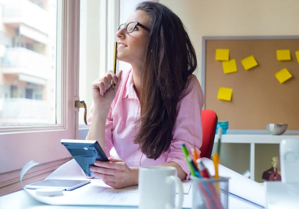 Belle jeune femme travaillant dans son bureau. — Photo