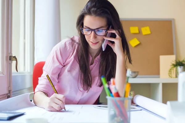 Vacker ung kvinna som arbetar på sitt kontor. — Stockfoto