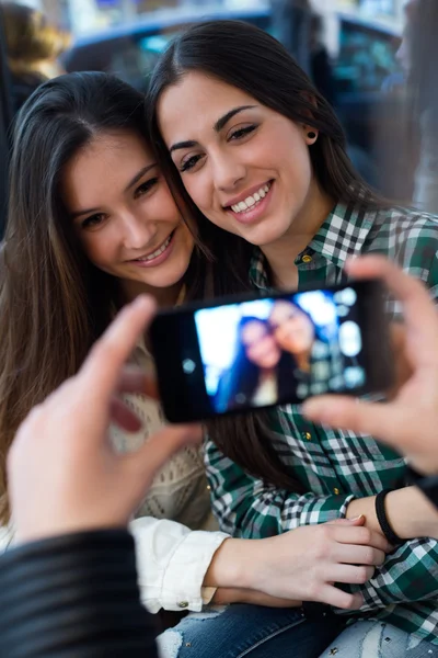 Три девушки пользуются мобильным телефоном в кафе . — стоковое фото