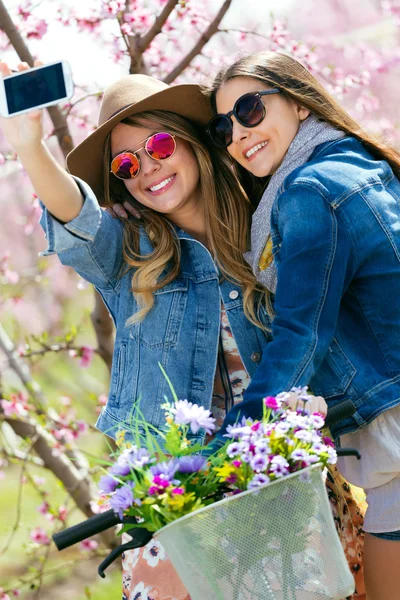 Dwa piękne młode kobiety przy selfie w polu. — Zdjęcie stockowe