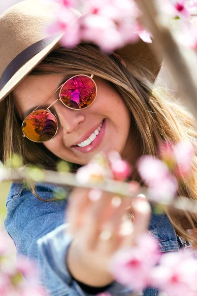 Hermosa joven con flores en el campo . — Foto de Stock