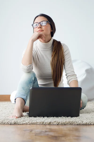 Schöne junge Frau arbeitet zu Hause an ihrem Laptop. — Stockfoto