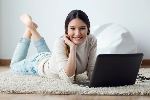 Mooie jonge vrouw werken op haar laptop thuis. — Stockfoto