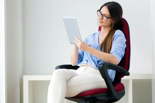 Schöne junge Frau arbeitet mit digitalem Tablet. — Stockfoto