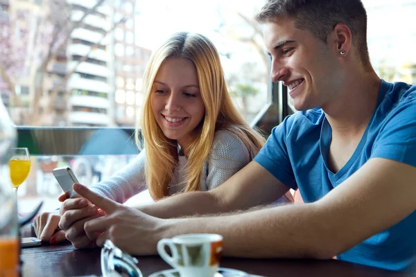 Group of friends using mobile phone in cafe. — Stock Photo, Image