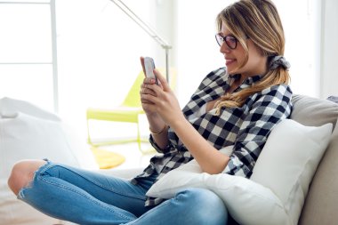 Güzel genç kadın cep telefonu evde kullanma.