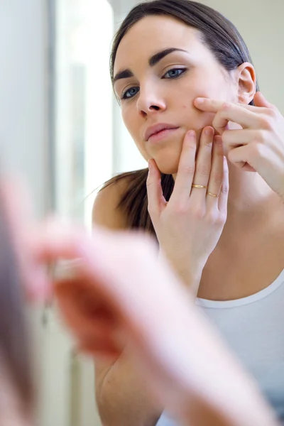 Femme prenant soin de sa belle peau sur le visage debout près de mir — Photo