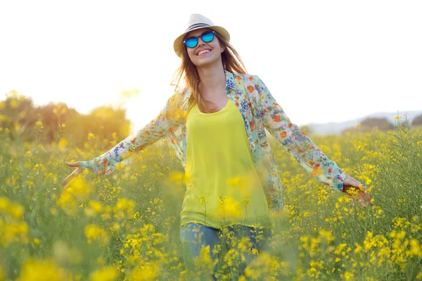 Hermosa joven disfrutando del verano en un campo . — Foto de Stock