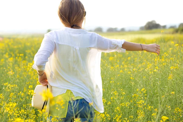 Schöne junge Frau genießt den Sommer auf einem Feld. — Stockfoto