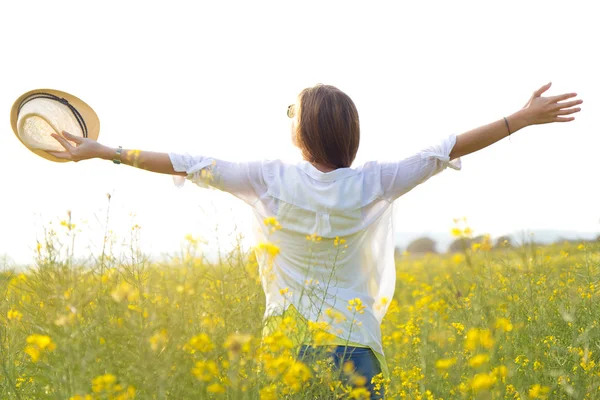 Schöne junge Frau genießt den Sommer auf einem Feld. — Stockfoto