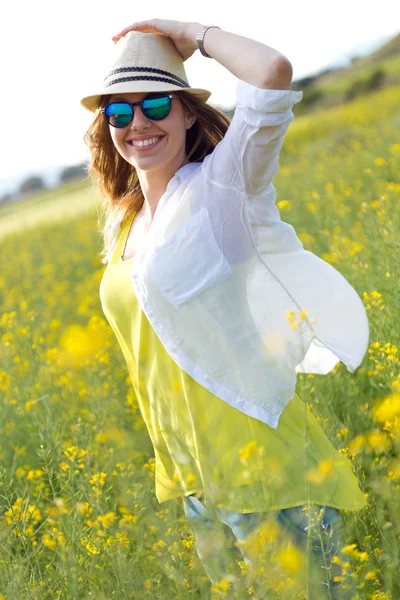 Schöne junge Frau genießt den Sommer auf einem Feld. — Stockfoto