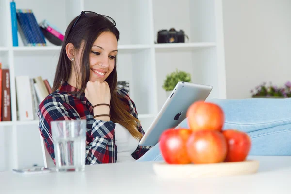 Krásná mladá žena doma pomocí její digitální tabletu. — Stock fotografie