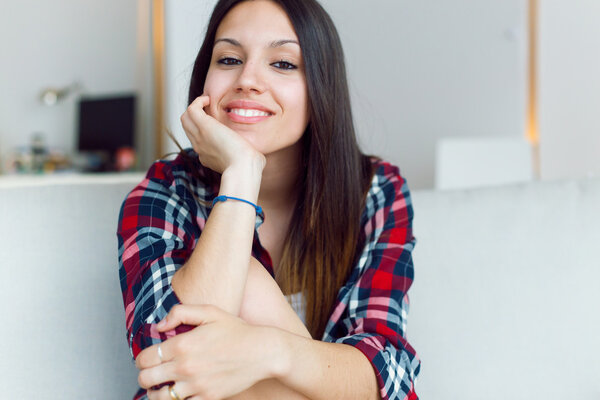 Beautiful young woman looking at camera at home.