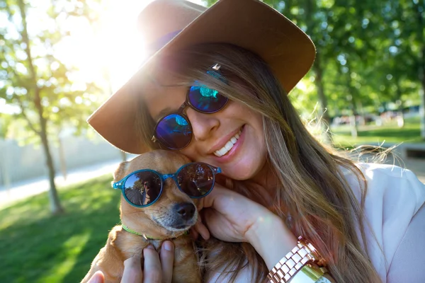 Belle jeune femme regardant la caméra avec son chien . — Photo