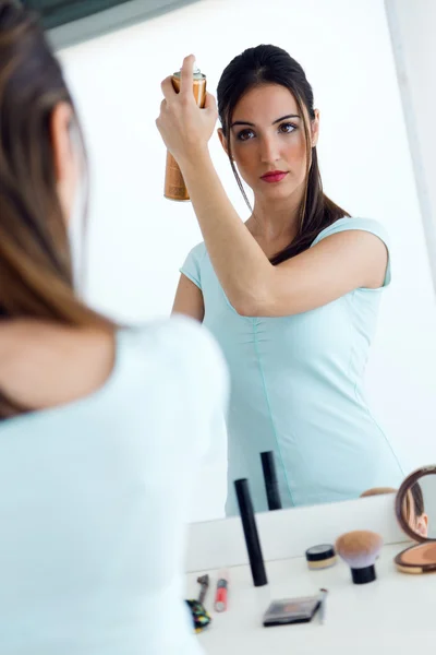 Unga vackra kvinnan att göra frisyr nära spegel. — Stockfoto