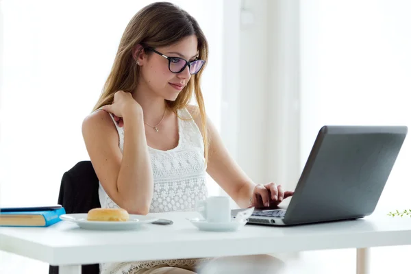 Mujer bastante joven usando su portátil en casa . — Foto de Stock